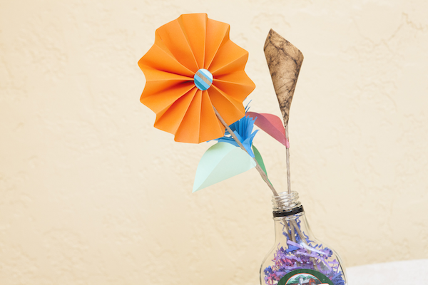 two paper flowers sticking up out of a jar