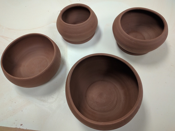 four brown clay bowls, unglazed