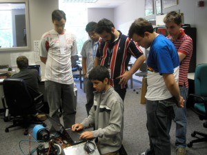 a group of men standing around a robot