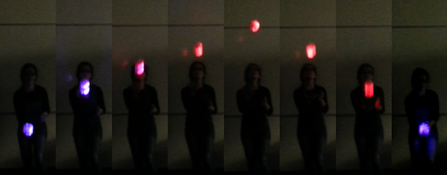 series of images of person tossing a glowing ball in an arc, on the left it is blue, then it turns red, then back to blue, reflecting the ball's acceleration