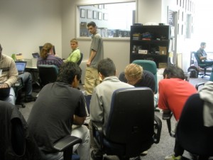 a group of people around computers