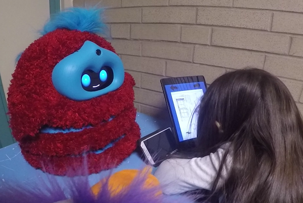 fluffy robot tells a story to a child, who leans in over a tablet storybook listening