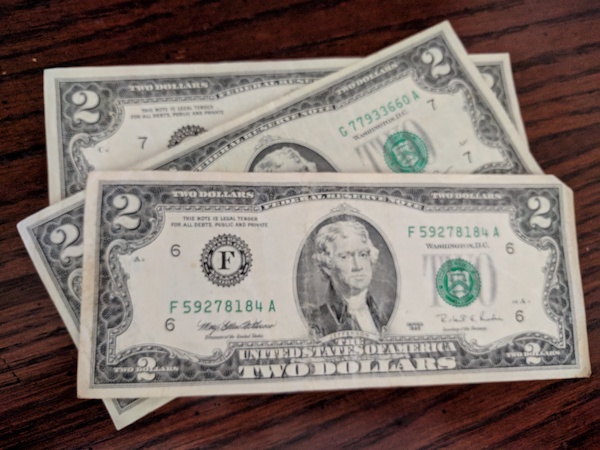 three two-dollar bills on a table